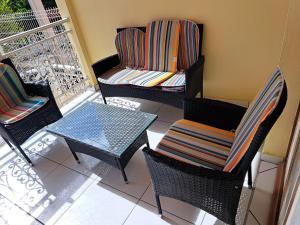 een balkon met stoelen en een tafel bij MAISON de VACANCES ANSES D'ARLET in Les Anses-dʼArlets