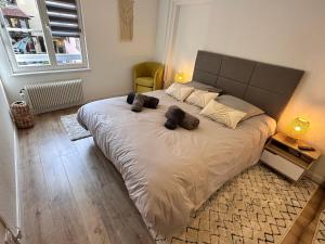 a bedroom with a large bed with two stuffed animals on it at Le bijou de Leyna in Colmar