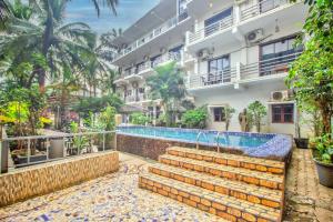 a hotel with a swimming pool in front of a building at GOA Down D Vilage Prime in Candolim