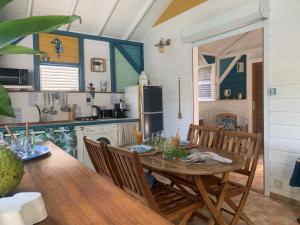 a kitchen with a table and chairs and a refrigerator at Un p'tit coin Zen in Saint-François