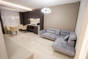 - un salon avec un canapé et une table dans l'établissement Deluxe Aparthotel MARWELL RESIDENCE, à Suceava