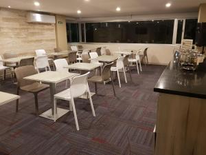 a dining room with tables and chairs and a bar at Hotel Arawak Plaza in Sincelejo