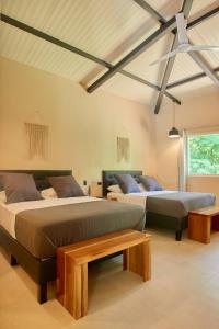 a bedroom with two beds and a table in it at LaLola Villa Privada in Cahuita