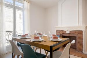 une salle à manger avec une table, des chaises et une cheminée dans l'établissement Appartement T2 de haut standing classé trois étoiles, hypercentre Rochefort, arrivée autonome, à Rochefort