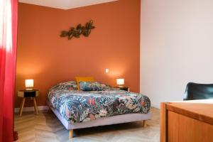 - une chambre dotée d'un lit avec un mur orange dans l'établissement Appartement T2 de haut standing classé trois étoiles, hypercentre Rochefort, arrivée autonome, à Rochefort