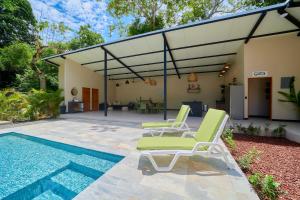 a patio with two lounge chairs and a swimming pool at LaLola Villa Privada in Cahuita