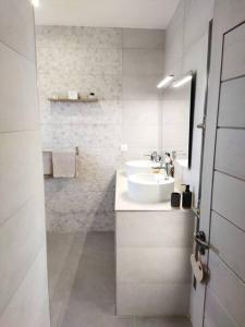 La salle de bains blanche est pourvue d'un lavabo et d'un miroir. dans l'établissement VILLA BELLE VUE, à Saint-Louis