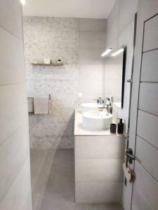 une salle de bain blanche avec un lavabo et un miroir dans l'établissement VILLA BELLE VUE, à Saint-Louis