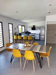 une salle à manger avec une table et des chaises jaunes dans l'établissement VILLA BELLE VUE, à Saint-Louis