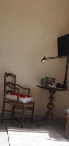 Zimmer mit einem Stuhl und einem Tisch mit einer Lampe in der Unterkunft Tigmi Anis in Essaouira