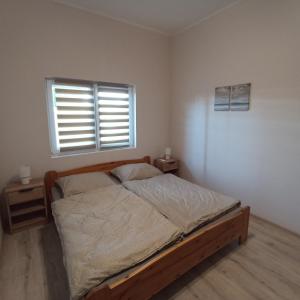 佐馬爾迪的住宿－Zafír Vendégház，一间卧室配有一张带窗户和木制床架的床