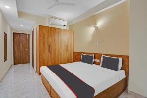1 dormitorio con 1 cama grande y armario de madera en Collection O Rm Residency Near Appu Ghar, en Gurgaon