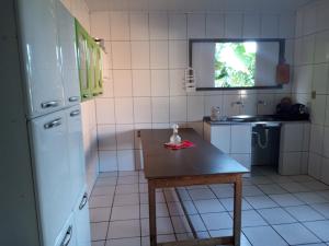 a small kitchen with a table and a refrigerator at Casa da paty in Santa Cruz Cabrália