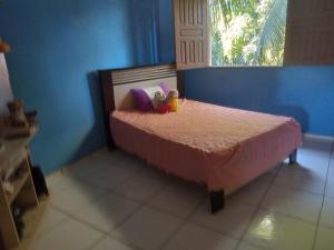 two stuffed animals sitting on a bed in a bedroom at Casa da paty in Santa Cruz Cabrália