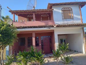 uma casa vermelha e branca com um moinho de vento em Casa da paty em Santa Cruz Cabrália