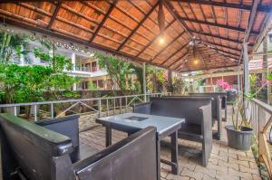 eine Terrasse mit Tischen und Stühlen und einem Holzdach in der Unterkunft GOA Down D Vilage Prime in Candolim