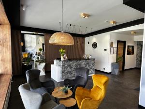 a living room with yellow chairs and a table at WRZOS resort & wellness in Węgierska Górka