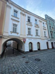 a large white building with an arch in a street at Hotel Zámecká 17 in Pardubice