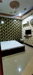 a bedroom with a bed in a room with a wall at Hotel New Star View in Bahawalpur