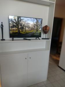 a flat screen tv sitting on top of a white entertainment center at BlasHouses in San Rafael