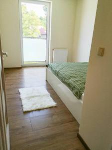 a bedroom with a bed and a window and a rug at Apartament Hubertus in Bochnia