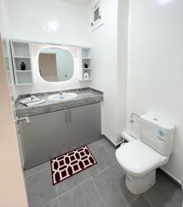 uma casa de banho com um WC, um lavatório e um espelho. em Appartement Vue Sur Piscine Imi Ouaddar Taghazout em Agadir nʼ Aït Sa