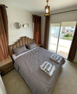 um quarto com uma cama grande com duas almofadas em Appartement Vue Sur Piscine Imi Ouaddar Taghazout em Agadir nʼ Aït Sa