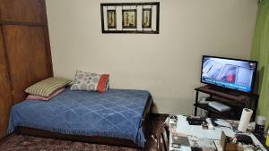 1 dormitorio con 1 cama y TV de pantalla plana en Mundo Felix en Buenos Aires