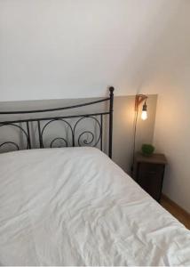 ein Schlafzimmer mit einem weißen Bett und einer Lampe in der Unterkunft Chambre d'hôte proche d'Étretat in Saint-Jouin-Bruneval