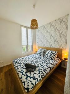Schlafzimmer mit einem Bett mit einer blauen und weißen Bettdecke in der Unterkunft SAINT DENIS 2 Chambres , 8min Porte Chapelle-8min Stade de France in Saint-Denis