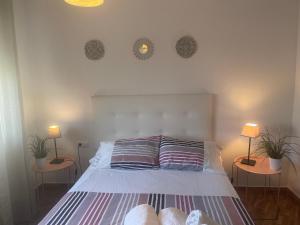 a bedroom with a bed with two lamps and two plants at Apartamento Mirador del Atlántico in Conil de la Frontera