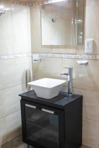 La salle de bains est pourvue d'un lavabo blanc sur un comptoir noir. dans l'établissement Trevelin Houses, à Trevelín