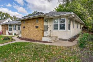 a small brick house with a porch at Cozy Minneapolis Duplex - 10 Mi to Downtown! in Minneapolis
