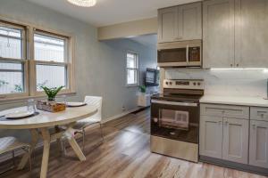 a kitchen with a table and a dining room at Cozy Minneapolis Duplex - 10 Mi to Downtown! in Minneapolis