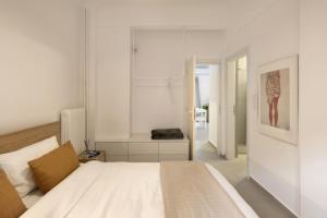 a white bedroom with a bed and a bathroom at Kerameikou25 large in Athens