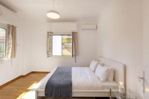 a white bedroom with a bed and a couch at Kerameikou25 small in Athens