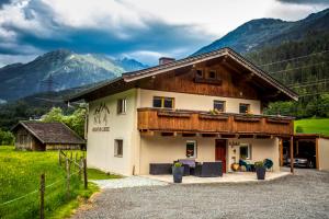dom w górach z górami w tle w obiekcie Mountain Lodge w mieście Neukirchen am Großvenediger