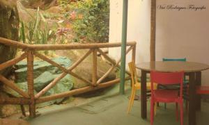 una mesa y sillas en una habitación con una mesa y una valla en Pousada Maravilha de Ará, en Praia de Araçatiba
