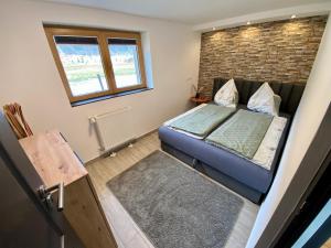 mała sypialnia z łóżkiem i ceglaną ścianą w obiekcie Mountain Lodge w mieście Neukirchen am Großvenediger