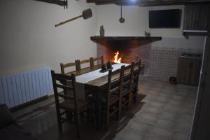 cocina con mesa, sillas y chimenea en Casa Rural Fuente de la Plata, en Molinicos