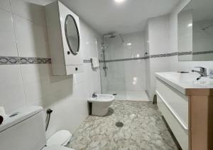 Baño blanco con lavabo y aseo en CHINASOL Low Cost, en Almuñécar