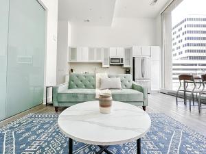 a living room with a green couch and a table at Sleepover Exclusive 1BD 1BA Downtown Kansas City Apartments in Kansas City