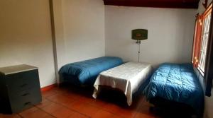 Cette chambre comprend 2 lits et une commode. dans l'établissement Lugar clave, à Cerrillos
