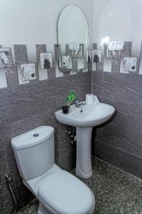 y baño con aseo, lavabo y espejo. en Aqualina Villa, en Matara