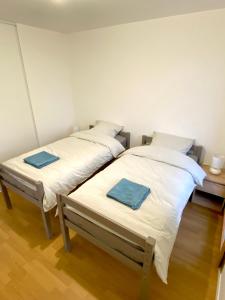 twee bedden naast elkaar in een kamer bij Neuf, vue panoramique, calme, spacieux, propre in Asnières-sur-Seine