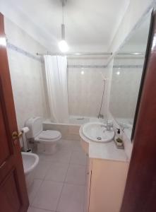 Un baño blanco con inodoro y lavabo. en Apartamento Amarelinha, en Lagos