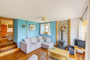 uma sala de estar com um sofá e uma lareira em The Steading at Castle Creavie Farm em Kirkcudbright