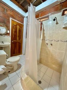 a bathroom with a shower and a toilet at The Sea Garden House in Olón