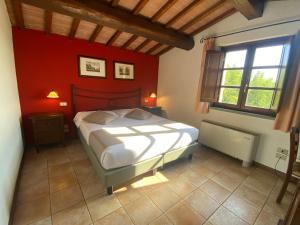 1 dormitorio con cama y pared roja en La Locanda dei Golosi, en Bosco