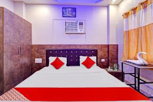 A bed or beds in a room at Flagship Saharsh Hotel